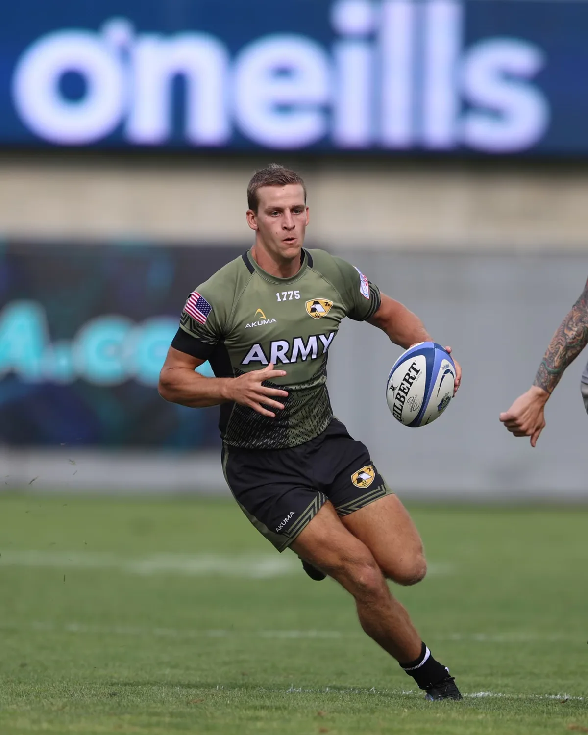 Ben running with a rugby ball mid-match