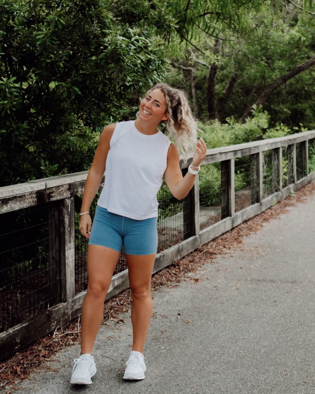 Lyla smiling on a boardwalk under the trees