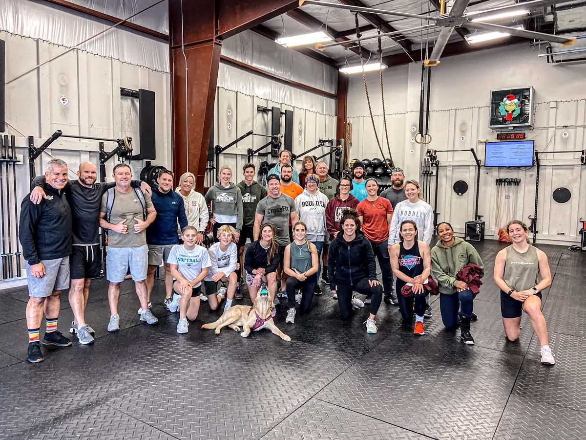 The Momentum Fitness crew and the gym dog together on the gym floor
